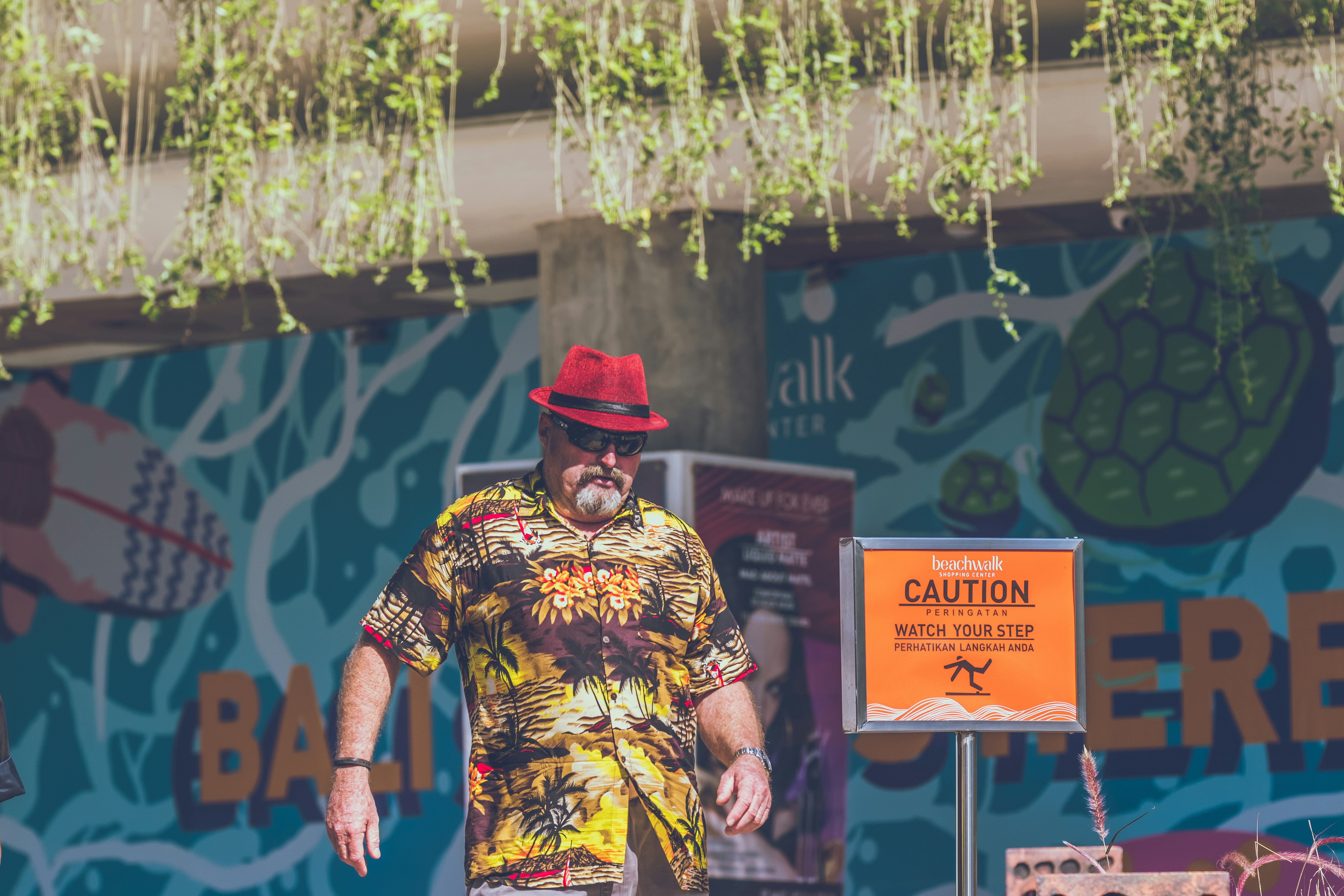 man standing near caution signage